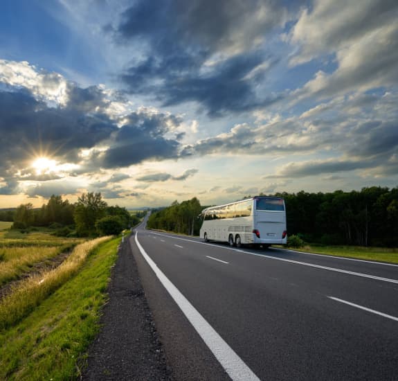 a white charter bus on the road